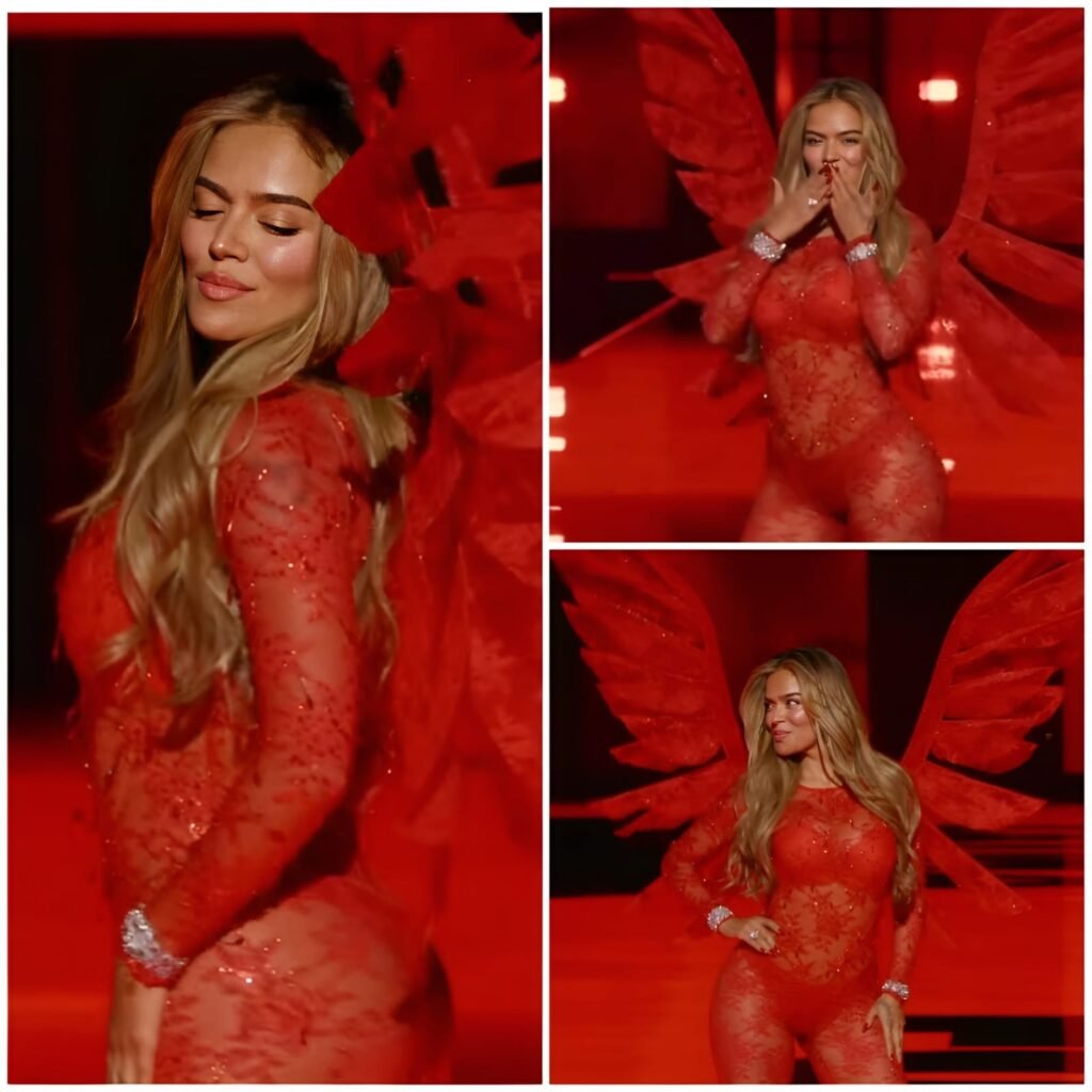 Karol G performing live on stage with red wings symbolizing Latin power.